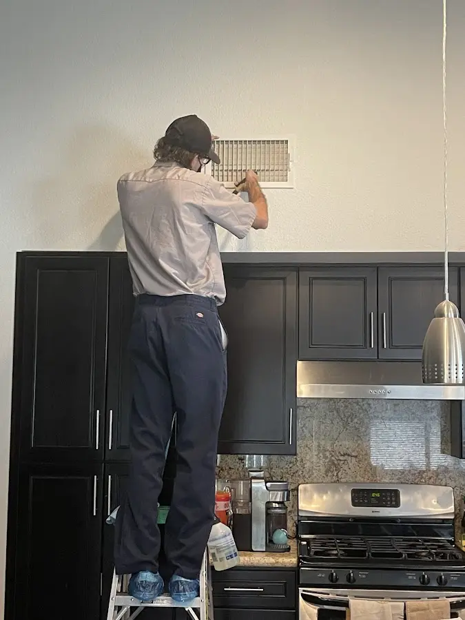 Technician inspecting an air vent during HVAC service in Yeadon
